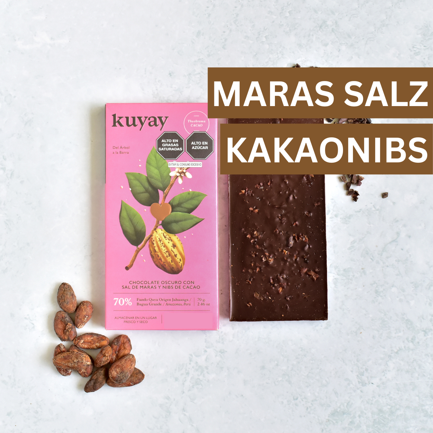 Kuyay Schokolade mit Maras-Salz und Kakaonibs in rosa Verpackung, stilvoll fotografiert mit Kakaobohnen – edle Kombination aus Salz, Crunch und 70 % Kakao