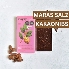 Kuyay Schokolade mit Maras-Salz und Kakaonibs in rosa Verpackung, stilvoll fotografiert mit Kakaobohnen – edle Kombination aus Salz, Crunch und 70 % Kakao