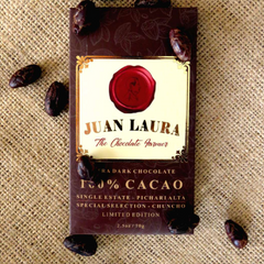 late Farmer. Die Verpackung ist braun mit einem roten Siegel und goldenen Verzierungen. Auf der Verpackung steht '70% CACAO', 'Single Estate - Pichari Alta', 'Special Selection - Chuncho', 'Limited Edition' und '2.5 oz / 70 g'. Die Schokoladenverpackung liegt auf einer Jutestoff-Oberfläche und ist von Kakaobohnen umgeben.