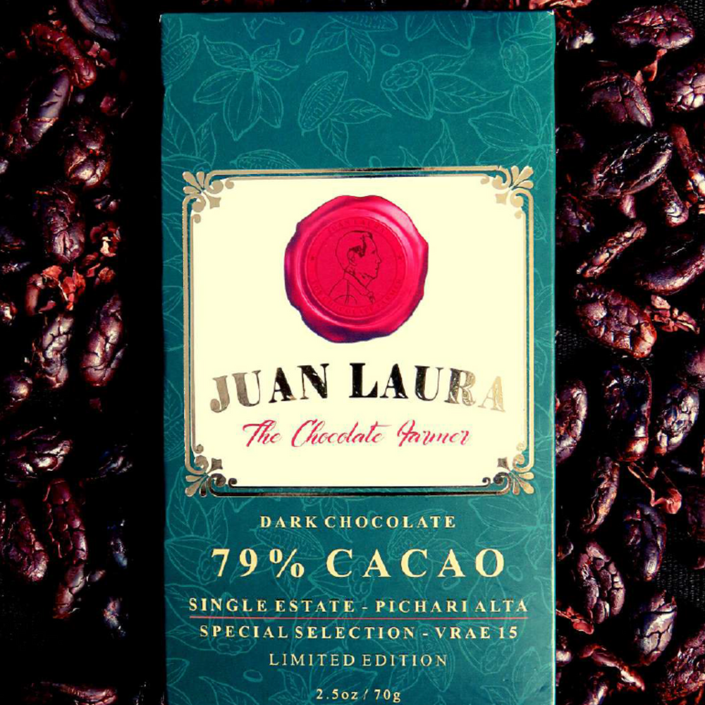 Verpackung der 79% dunklen Schokolade von Juan Laura mit rotem Siegel und grünem Muster, umgeben von Kakaobohnen. Text: '79% CACAO', 'Single Estate - Pichari Alta', 'Special Selection - Vrae 15', 'Limited Edition', '2.5 oz / 70 g'.