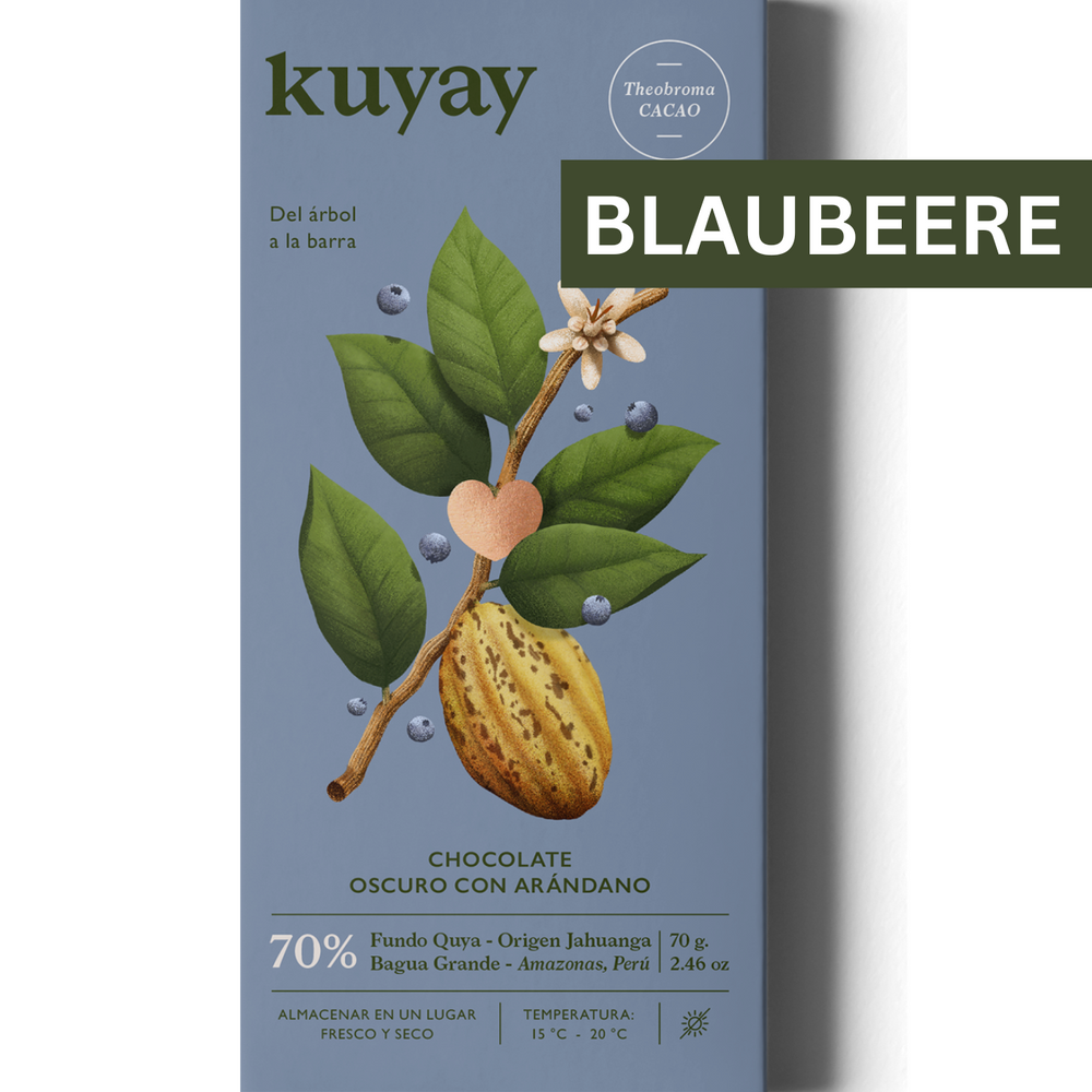Produktverpackung der Kuyay 70% Dunkle Schokolade mit Blaubeeren, auf einem blauen Hintergrund präsentiert. Die Verpackung zeigt eine Illustration eines Kakaobaums mit einer Kakaoschote, umgeben von kleinen Blaubeeren. Oben rechts ist ein braunes Label mit der Aufschrift "BLAUBEERE" angebracht.
