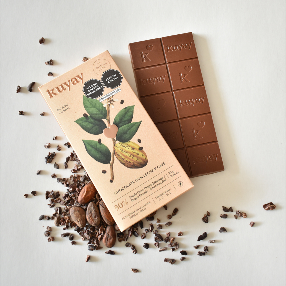 Geöffnete Kuyay Milchschokoladentafel 50% Kakao mit Kaffee, neben der Verpackung, angerichtet mit Kakaobohnen und Schokoladenstückchen auf hellem Hintergrund, Bio-zertifiziert, Amazonas, Peru.